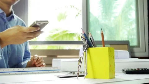 Close-up of pencil box with architect working and answer the phone Stock Footage