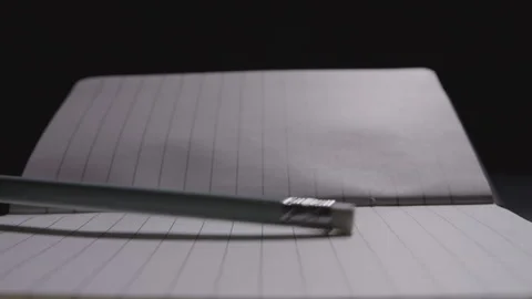 Close up of a pencil poking on an open notebook 動画素材 332728800