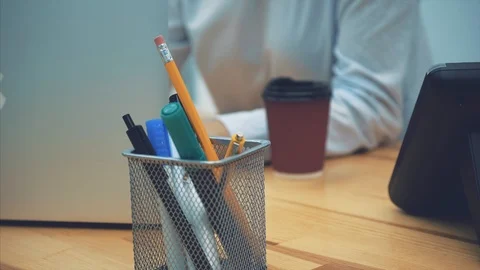 Close-up of pens pencils markers on the table. During this blurry young business Stock Footage 104226228