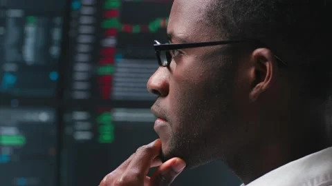 Close up of pensive African-American programmer looking at computer monitors Stock Footage 193643550