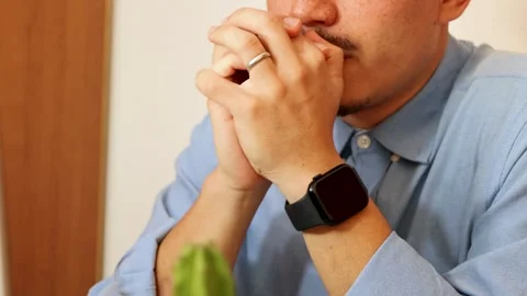 Close up of pensive young man holding pen in hand while working from computer Stock Footage 292875411