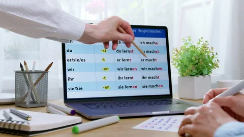 Close-up of people pointing with a pencil at German grammar words on a laptop  스톡 동영상 342229351