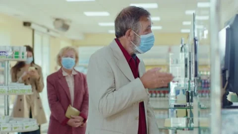 Close up people standing in line in the pharmacy. In medical masks. Inside Stock Footage 140763170