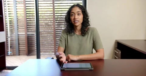 Close-up of people talking to the camera, using tablet, woman sitting at desk in Stock Footage 345877680
