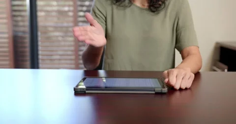 Close-up of people talking to the camera, using tablet on wooden table, woman Stock Footage 346134801