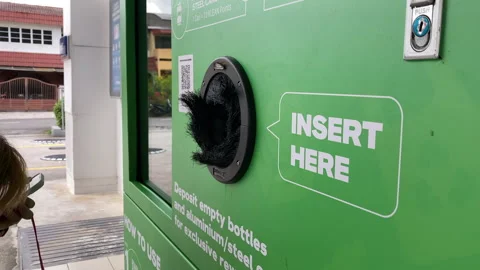 Close-up of people using reverse vending recycling machine for ESG video Stock Footage 312439382