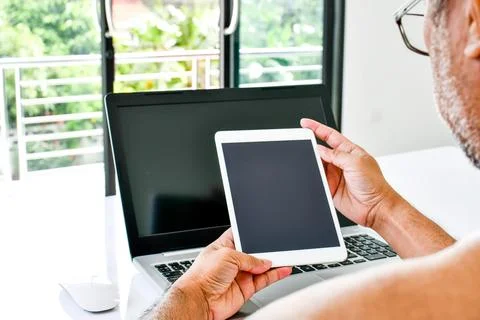 Close Up, People using the tablet device at home. A man holds a white table.. Stock Photos