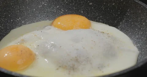 Close-up of peppering sunny-side up in slow motion. Cooking fried eggs in a pan Stock Footage 252726918