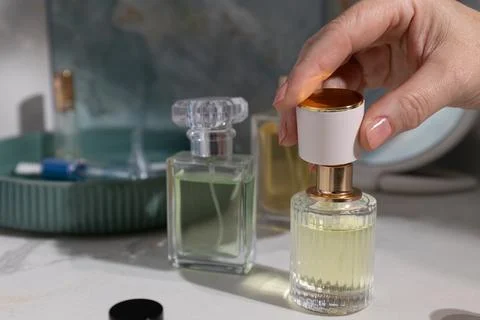 Close up of a perfume bottle cap being lifted ready to spray on a bathroom .. Stock Photos