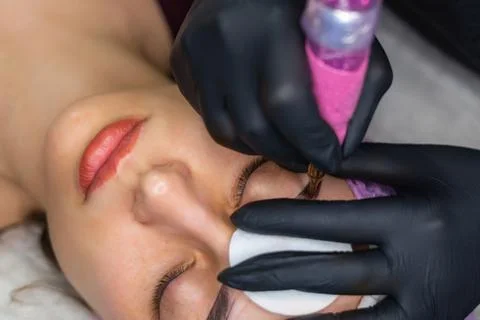 Close up of permanent eyebrow makeup procedure, beautician performing Stock Photos