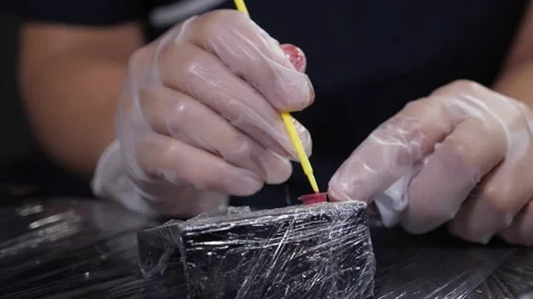 A close-up of the permanent makeup artist mixes pink ink in a small container. Stock Footage 315093372
