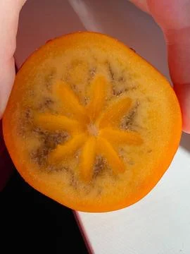 Close-Up of a Persimmon Slice with Star Pattern Stock Photos