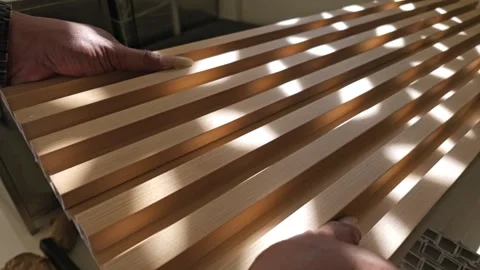 Close up of person assembling fluted wall panels joining WPC wood look panels Stock Footage 340002202