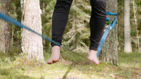 Close-up of person balancing on a slackline in a forest Stock Footage 292920952