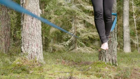 Close-up of person balancing on a slackline in a forest Stock Footage 292921014