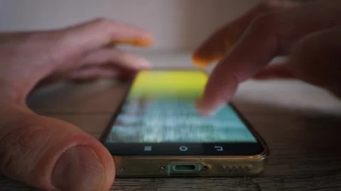 Close Up of Person Browsing Social Media on Smartphone Lying on Wooden Table 库存影片 339208751