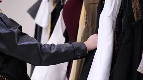Close up of a person browsing through a rack of clothes in a fashion store Vidéo 328612874