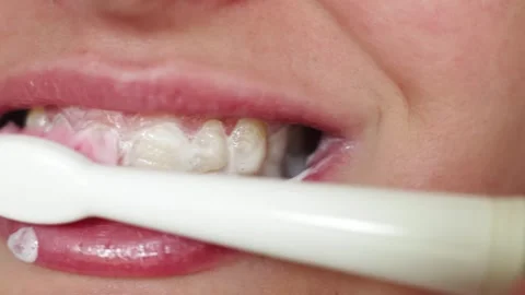 Close-up of person brushing teeth with electric toothbrush and toothpaste Stock Footage 340261345