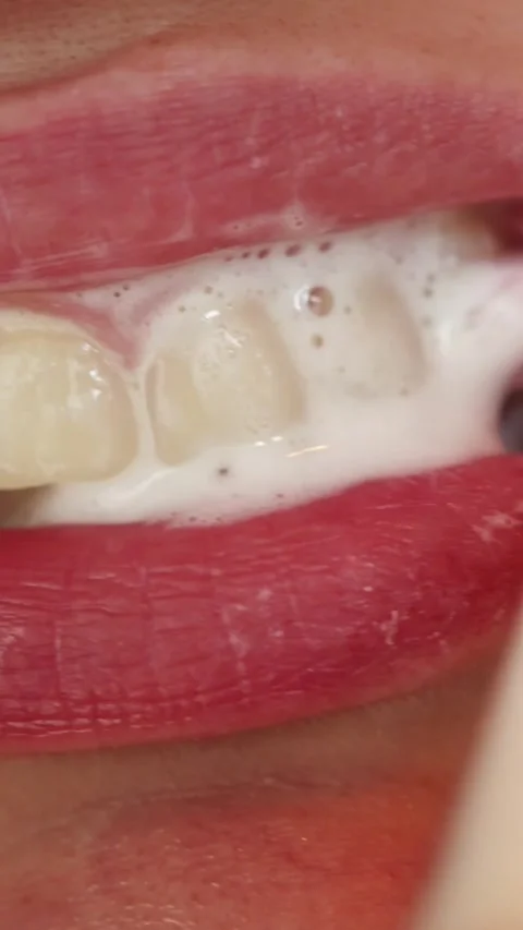 Close-up of person brushing teeth with foam and electric toothbrush Stock-Footage 343838166