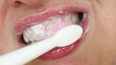 Close-up of person brushing teeth with white toothpaste and toothbrush Stock Footage 340261339