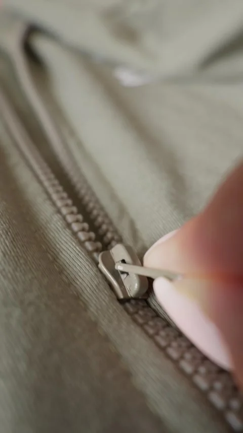 Close Up of Person Closing Zipper Tab on Khaki Green Canvas Jacket Video stock 338097667