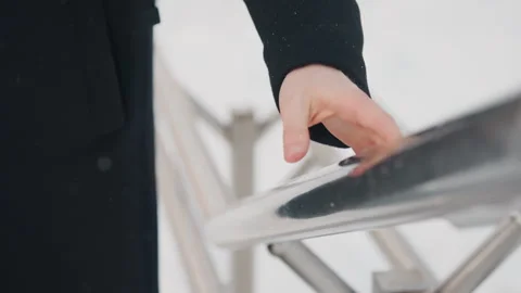 Close up person cold wet hands gripping and releasing metal railing in falling Stock Footage 345728364