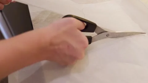 Close up of person cutting baking paper with scissors along drawn shape. Stock Footage 337441510