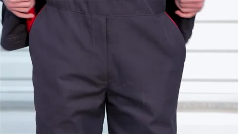 Close-up of a person in dark work pants standing beside a sleek car Stock Footage 311182108