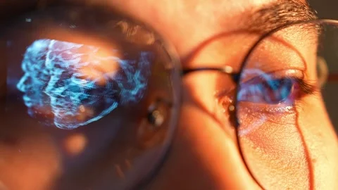 A close-up of a person with a digital human face mesh reflected. Video stock 324839403