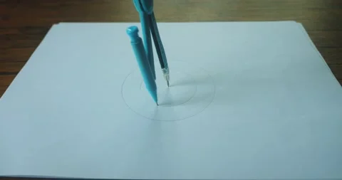 Close-up of a person drawing a geometric circle with a compass. Draw a circle on Stock Footage 236930248