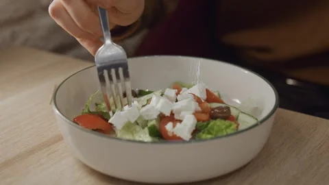 Close up of person eating fresh vegetable salad with fork in white bowl on Stock Footage 344869693