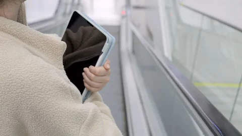 Close-up of person on escalator with tablet Stock Footage 341995202