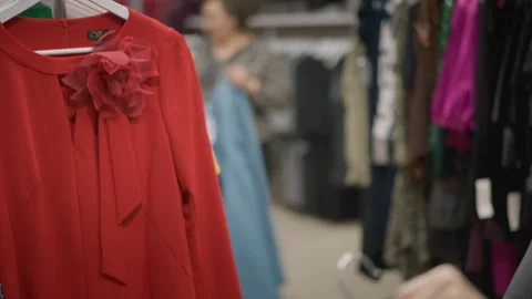 Close up of person examining red and black clothing with sequins in store Stock Footage 346730972