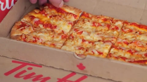 A close up of a person getting a Tim Hortons Flatbread Cheese Pizza slide. Stock Footage 233861199