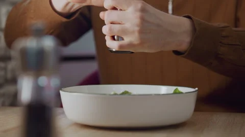 Close up person grinding pepper over food in calm indoor kitchen showing Stock-Footage 344870929