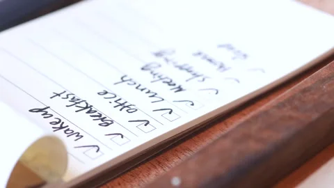 Close up of person hand checking on a to do list on a paper on table, video.. Stock Footage 333029739