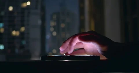 Close-up of person hand interacting with mobile phone lying on table. Late in Stock Footage 263178874