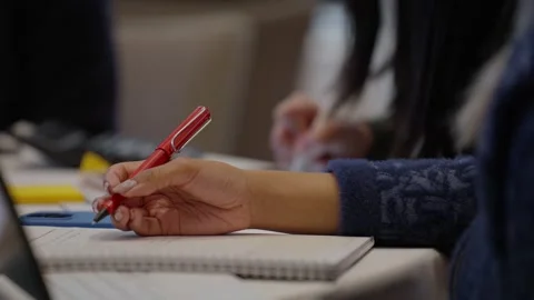 Close up a person hand taking notes, writes with a pen on paper on her notebook. Stock Footage 306993914
