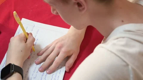 Close-up of a person hand writing on graph paper with a yellow pen. Stock Footage 311693813