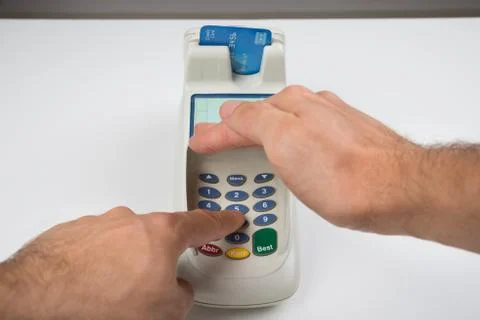 Close-up Of Person Hands Entering Code In A Card Reader Machine Foto stock