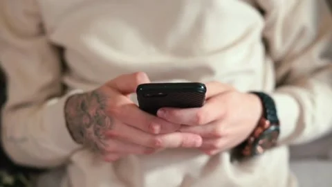 Close-up of person hands with tattoo using smartphone or cell phone Tapping.. Stock Footage 272781348