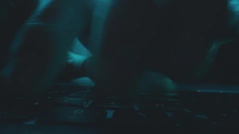 Close up of person hands typing fast on laptop keyboard in dark room with b.. Stock Footage 337532711