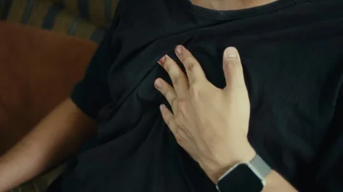 Close-up of person holding chest with both hands in discomfort Stock Footage 324859376