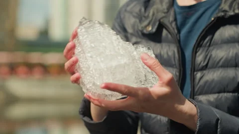 Close up of person holding large clear ice crystal with visible texture details Stock Footage 345045822