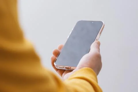 Close up of person holding smartphone with empty dark display mockup for appl Stock Photos