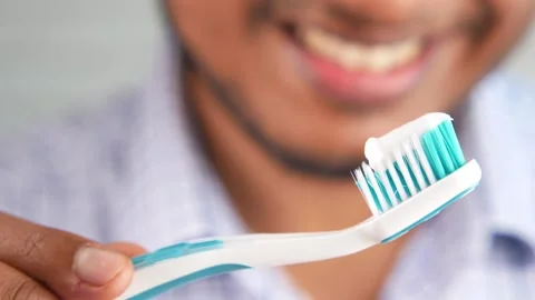 Close up of person holding toothbrush with toothpaste smiling brightly read.. 스톡 동영상 332745026