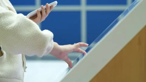 Close-up person interacts with touch screen while holding phone Video stock 345944084