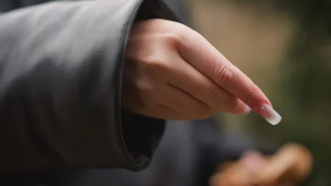 Close up of person long white nail sprinkling small particles with soft focus Stock Footage 346728627