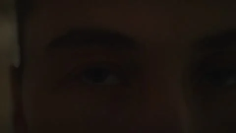 Close-up of a person looking into the camera in dim warm light... Vidéo 339101315