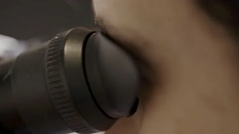 Close up - person looking inside a microscope to check an object up close Vídeo Stock 154279397